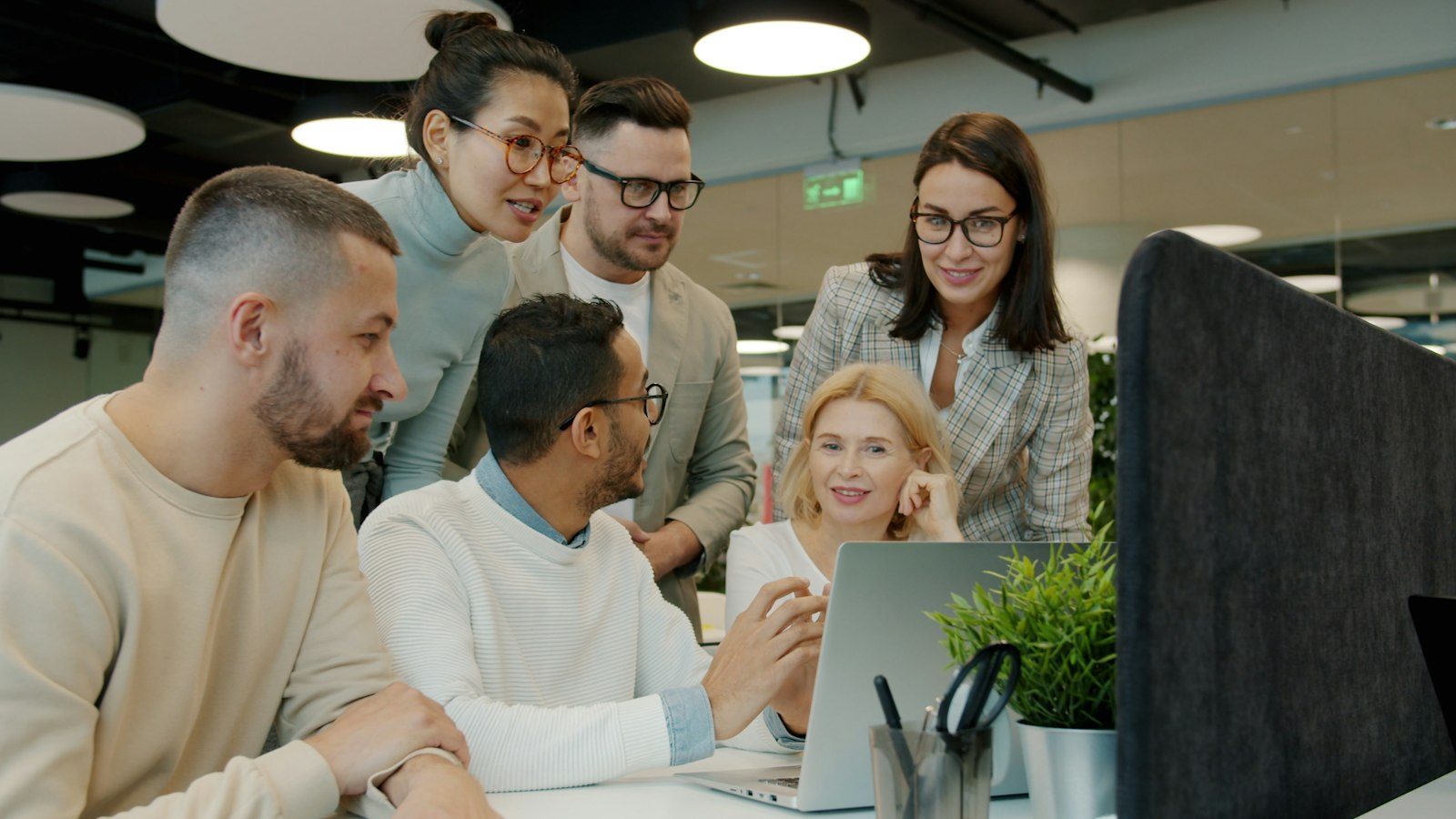 Team gathered around a laptop discussing a project